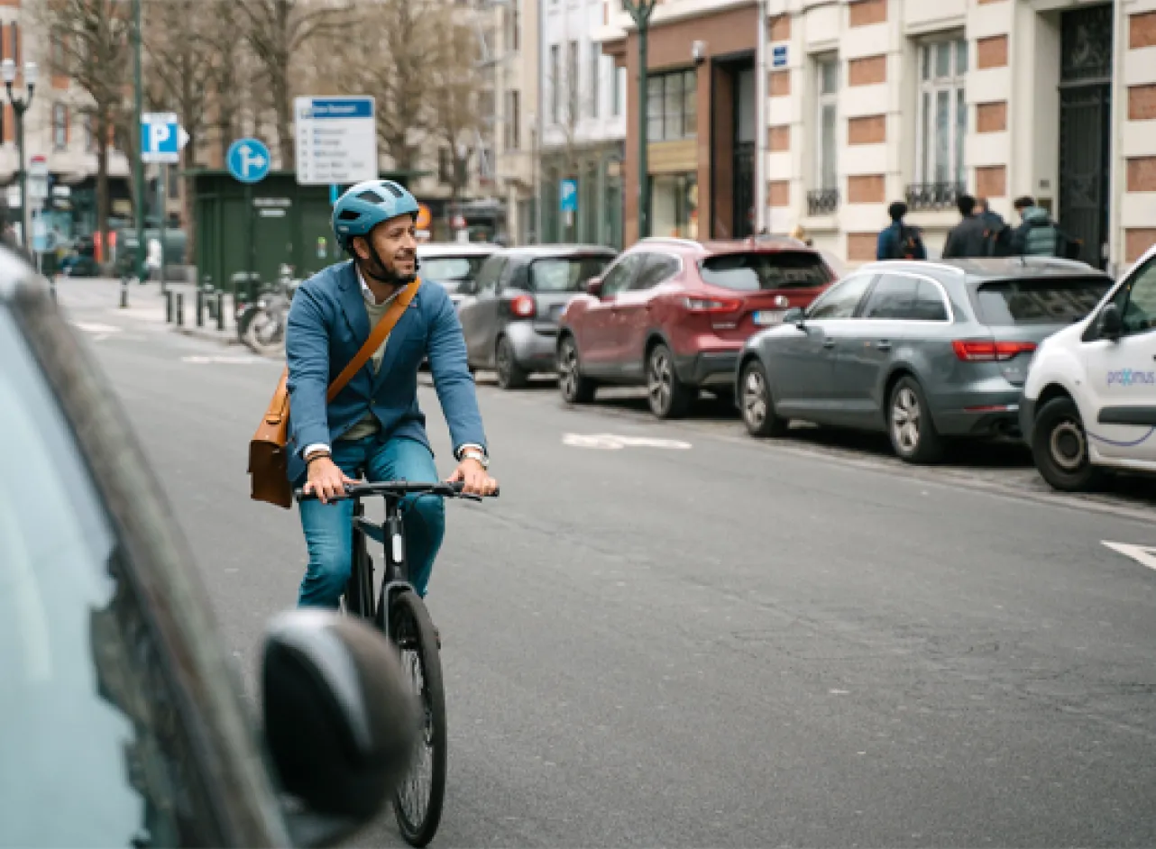 Un homme traverse une zone résidentielle à vélo